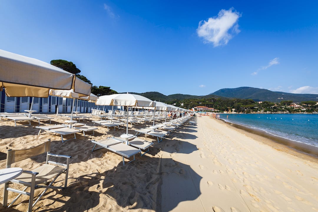 Una donna si gode un momento di relax sulla spiaggia di Fetovaia, all’Isola d’Elba.