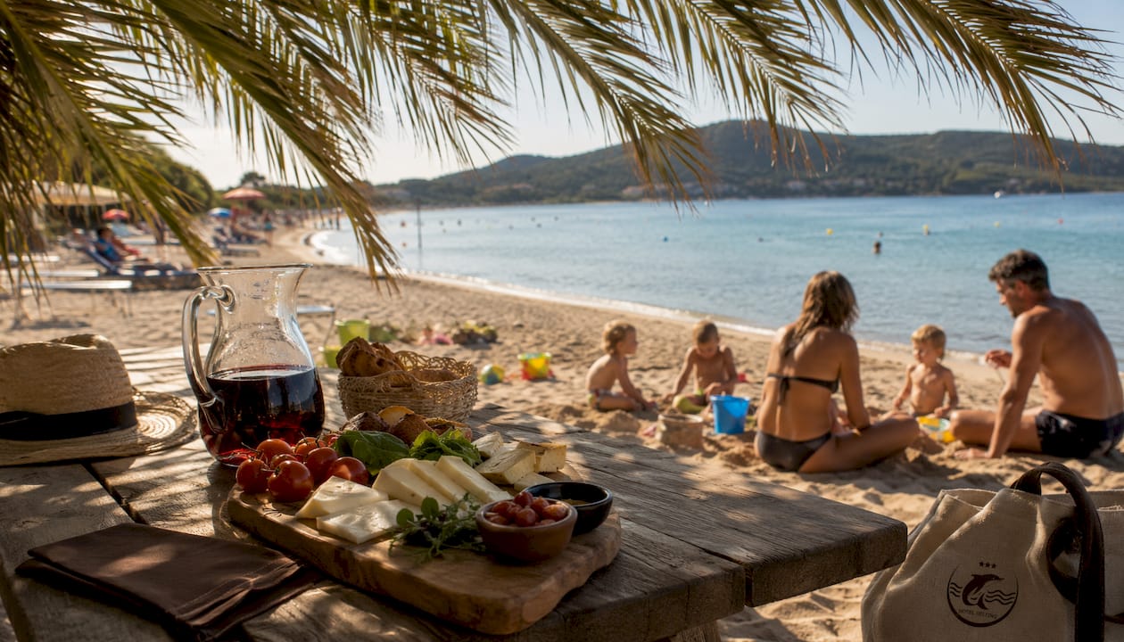 Una zona tranquilla in spiaggia dove gustare specialità locali all’ombra di alberi e palme